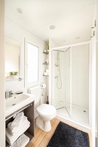 a white bathroom with a shower and a toilet at Mobile Homes AZZURRO in Rovinj