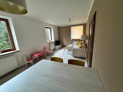 ein Zimmer mit Tisch und Stühlen und ein Schlafzimmer in der Unterkunft Apartmán Železná Ruda in Železná Ruda
