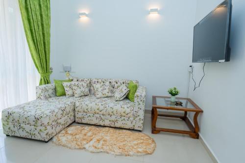 a living room with a couch and a tv at Green Retreat 2 Bedroom Hideout in Polgasowita