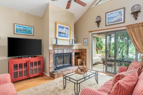 a living room with a television and a fireplace at Quiet Dataw Island Villa with Water Views in Dataw Island