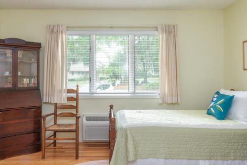 a bedroom with a bed and a chair and a window at Quiet Dataw Island Villa with Water Views in Dataw Island
