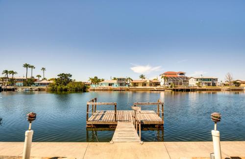 a dock in the middle of a lake with houses at Waterfront Florida Escape with Deck and Private Dock! in Hernando Beach