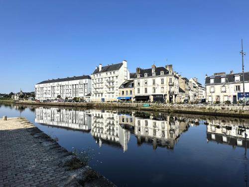 a group of buildings sitting next to a river at Maison de charme Locmaria in Quimper