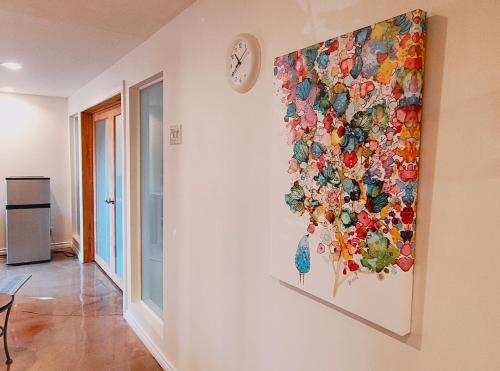 a painting of flowers on a wall with a clock at U of A Homestay, Trails & Whyte Ave in Edmonton
