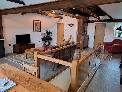 a living room with a table and a tv at The Fish Loft in Tewkesbury