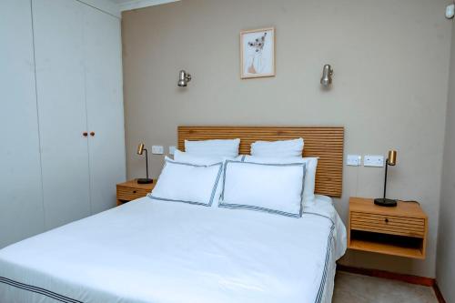a bedroom with a large white bed with white pillows at The Bush Cottage at Mokolodi Gaborone in Gaborone