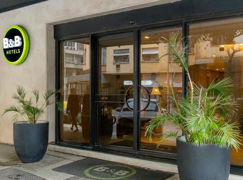 a store window with two potted plants in front of it at B&B HOTEL Rio Copacabana Posto 5 in Rio de Janeiro