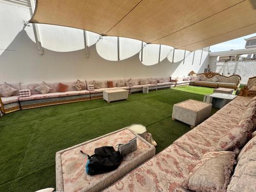 a large living room with couches and green grass at International Abu Dhabi Hostel in Abu Dhabi
