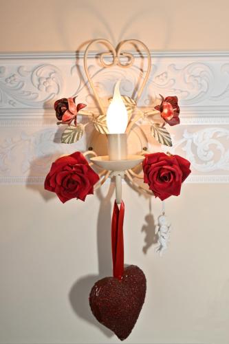 a chandelier with a heart and roses on a wall at Appartement Romantik in Warnemünde