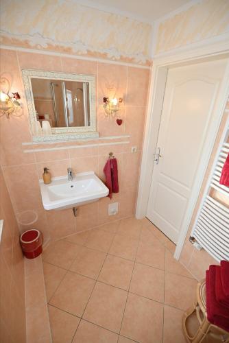 a bathroom with a sink and a mirror at Appartement Romantik in Warnemünde