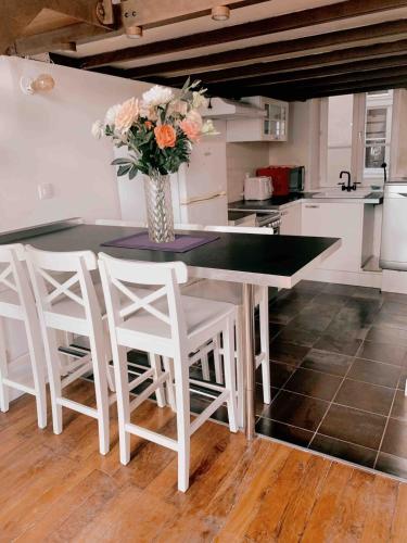 une cuisine avec une table avec un vase de fleurs dans l'établissement Cozy Loft City Center Croix-Rousse, à Lyon