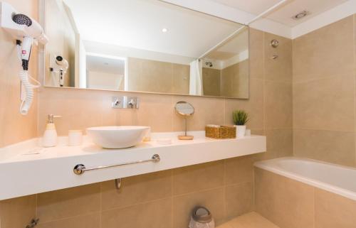 a bathroom with a sink and a tub at Gray Fox Apartments - Deloqui in Ushuaia