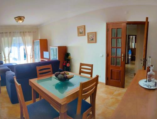 a living room with a table and a blue couch at Welkome Inn Estádio T2 in Portimão