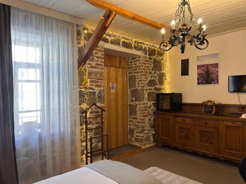 a bedroom with a bed and a window and a chandelier at Hnameni Stepanavan Guesthouse - Hotel in Stepʼanavan