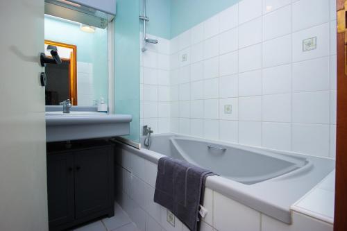 une salle de bain avec un lavabo et une baignoire dans l'établissement Appartement lumineux proche vieux port et centre historique, à La Rochelle