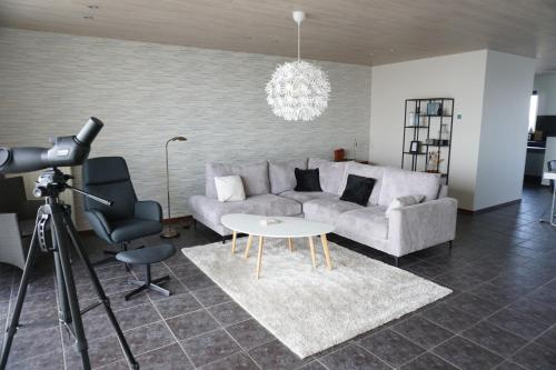 a living room with a couch and a table and a camera at Kustverhuur, Appartement aan Zee Port Scaldis 09051 in Breskens