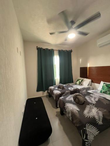 a room with three beds and a ceiling fan at Casa Monstera Bahia in Naranjo