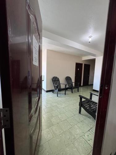 a room with two chairs and a room with a hallway at Panamá Hostels Inn in David