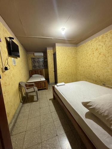 a bedroom with two beds and a television in it at Panamá Hostels Inn in David