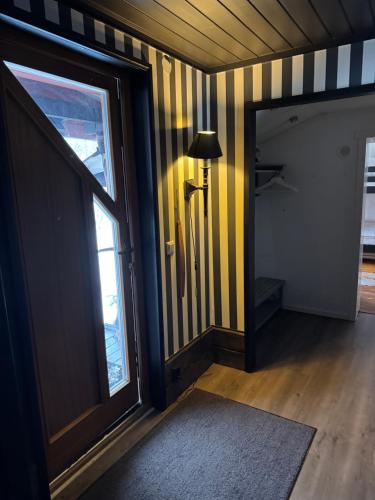 a hallway with yellow and black striped walls and a door at Sälen Osanden in Sälen