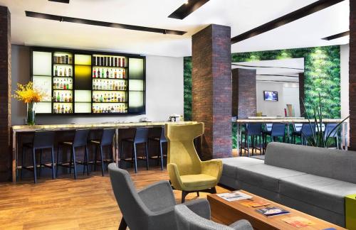 a bar in a restaurant with a couch and chairs at Hotel São Paulo - Premium Experience - Ibirapuera - Moema District in Sao Paulo