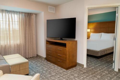 a hotel room with a bed and a flat screen tv at Staybridge Suites - Nashville - Franklin by IHG in Franklin