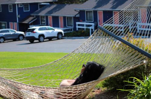 a woman laying in a hammock in a yard at Ocean View Terrace in Hampton Bays
