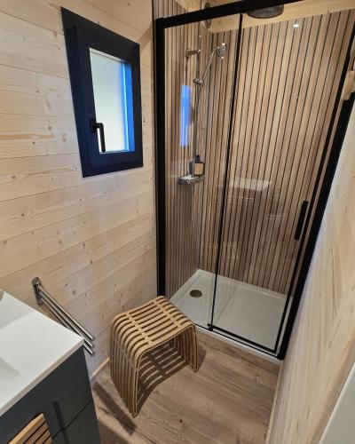 une salle de bain avec une douche avec un banc dedans dans l'établissement La Cabane Aixoise Piscine & Jacuzzi, à Aix-en-Provence