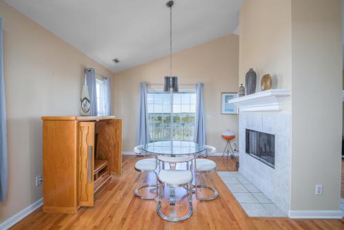 a dining room with a glass table and a fireplace at The Oyster's Pearl - Wonderful Views in Harbour Key in Fripp Island
