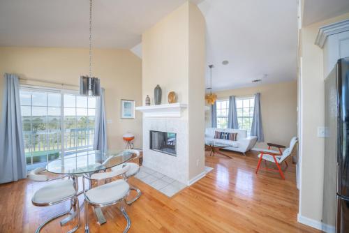 a living room with a glass table and a fireplace at The Oyster's Pearl - Wonderful Views in Harbour Key in Fripp Island