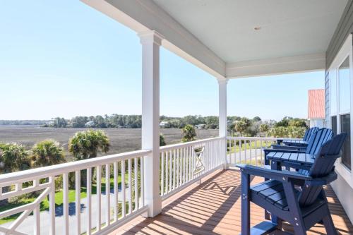 two blue chairs sitting on the porch of a house at Buried Treasure - Great Marsh Views on Harbor! in Nautical Watch Villas