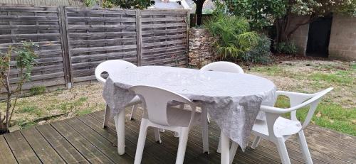 une table et des chaises blanches assises sur une terrasse dans l'établissement Appart'Jardin, à Saint-Pierre-des-Corps