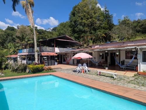 a swimming pool in front of a house at Finca Las Hamacas- La Posada del pensamiento in Santa Beatríz