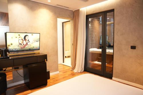 a living room with a television on a table at La Suite Boutique Hotel in Tirana