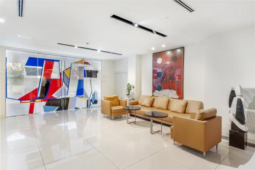 a living room with a couch and chairs and paintings at Art Hotel Navigli in Milan