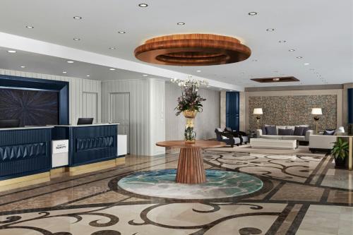 a lobby with a table in the middle of a room at Delta Hotels by Marriott Antalya Lara - Adult Only 18 Plus in Antalya