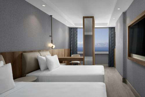 a hotel room with two beds and a television at Delta Hotels by Marriott Antalya Lara - Adult Only 18 Plus in Antalya