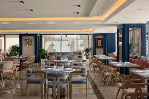 a dining room with tables and chairs and tablesktop at Delta Hotels by Marriott Antalya Lara - Adult Only 18 Plus in Antalya