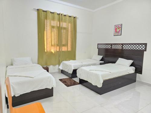 ein Zimmer mit zwei Betten und einem Fenster in der Unterkunft Turtle Guest House in Sur