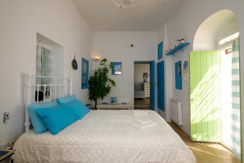 sypialnia z dużym łóżkiem z niebieskimi poduszkami w obiekcie Casa Annaise Mykonos - Cycladic Gem with Pool & Jacuzzi w mieście Mykonos