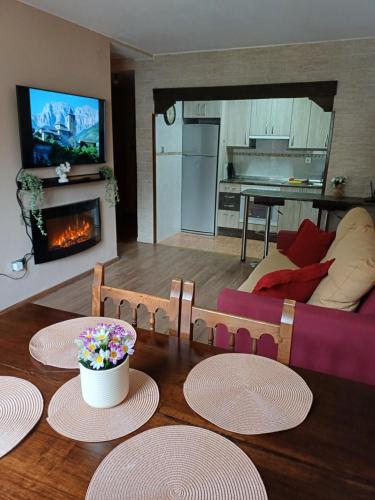a living room with a table and a fireplace at Apartamento con vistas al Parque Nacional de Ordesa y Monteperdido in Torla