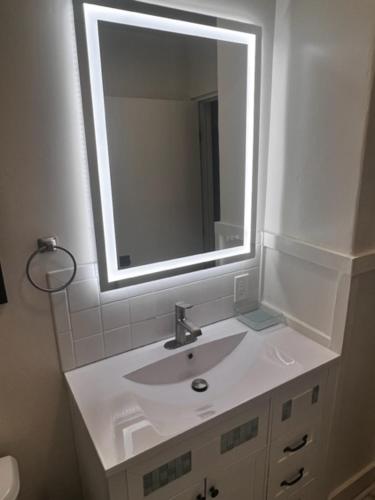 a white bathroom with a sink and a mirror at Reno MidTown Movie House in Reno