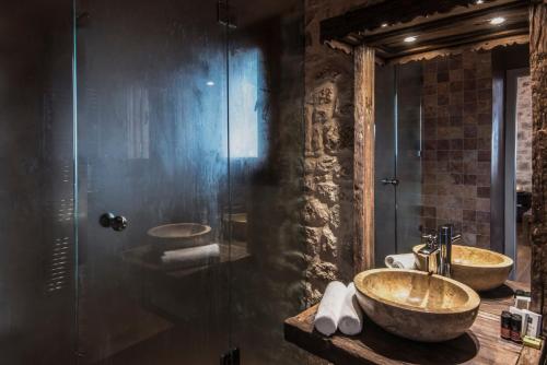 a bathroom with two sinks and a glass shower at Elafos Spa Hotel in Elliniko