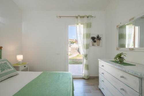 um quarto com uma cama, uma cômoda e uma janela em Villa Daniela- Costa Rei a 5 minuti a piedi dalla spiaggia con AC, WiFi e Parcheggi Privati em Costa Rei