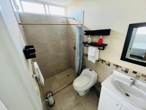 a bathroom with a toilet and a sink at Escápate a Manta Piscina y Confort in Manta