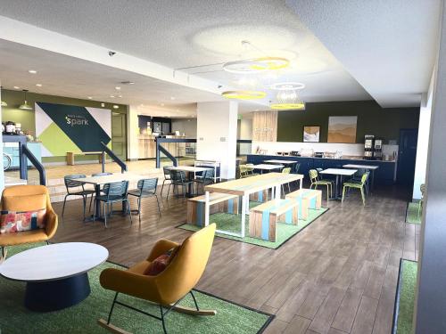 a lobby with tables and chairs and a cafeteria at Spark by Hilton Denver Tech Center Greenwood Village in Greenwood Village