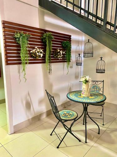 a table and chairs with plants on a wall at Hotel Neblina in Araguaína