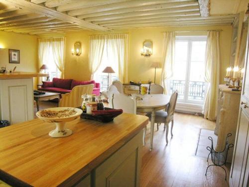une cuisine et un salon avec une table et des chaises dans l'établissement Beautiful 2 BDRM- In the heart of the Marais, à Paris