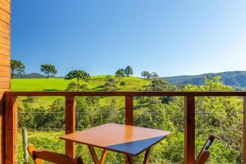 a table and chairs on a balcony with a view at Pousada Bracatinga in Bom Retiro