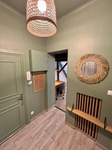 un couloir avec un banc et un miroir mural dans l'établissement Joli studio Avignon centre, à Avignon